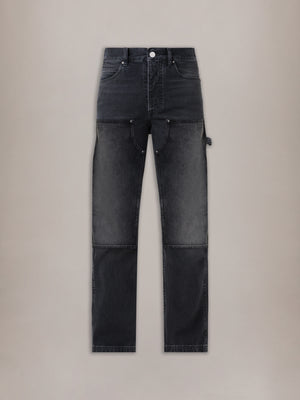 Vintage black carpenter jeans with contrasting panel sections, utility pockets, and white top button.