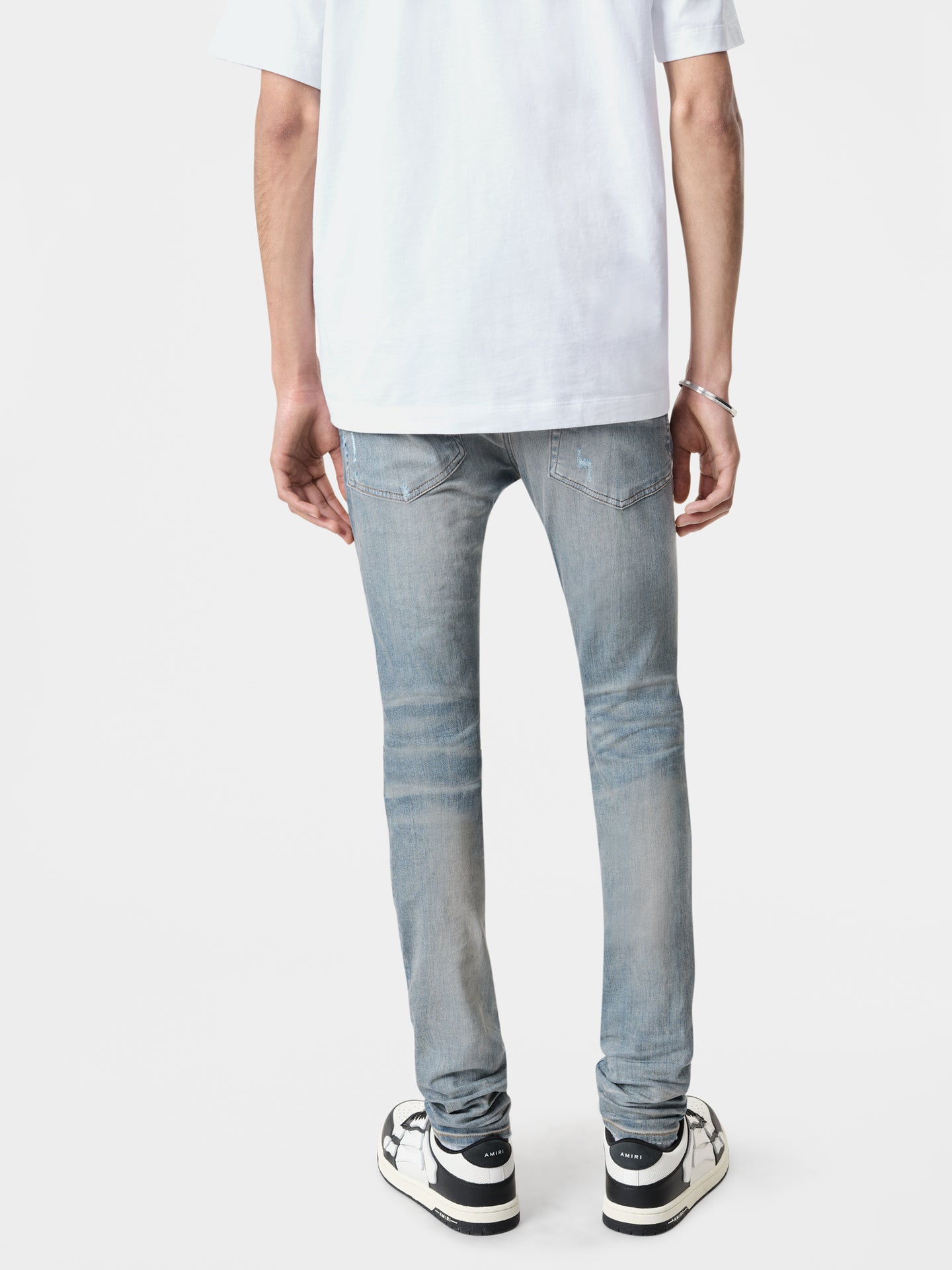 AMIRI Stack Jean in Clay Indigo with Amiri Logo Tee in White and Black White Classic Low Sneakers