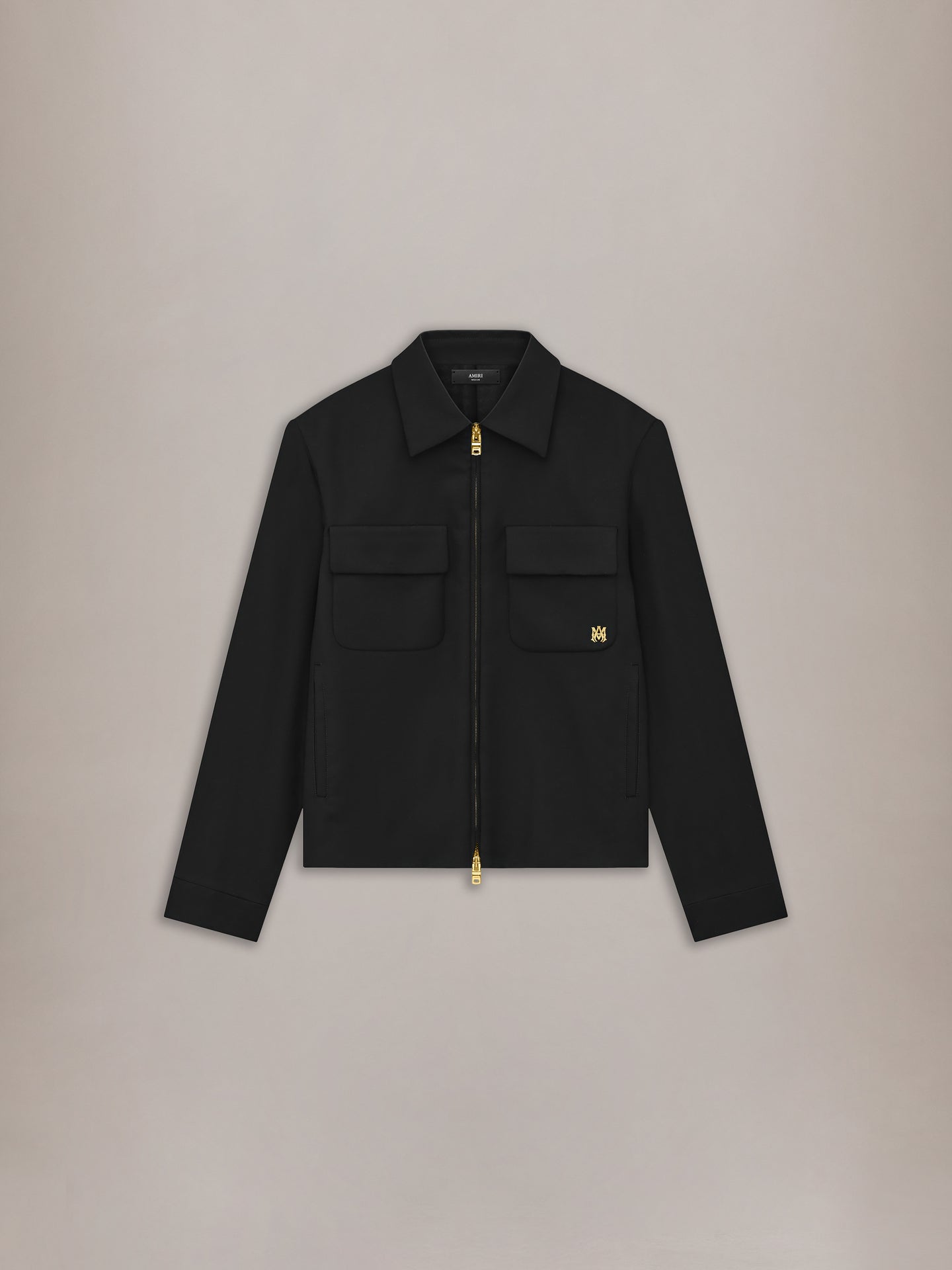 Black blouson jacket with collared neckline, front zip closure, and dual chest pockets with gold hardware.