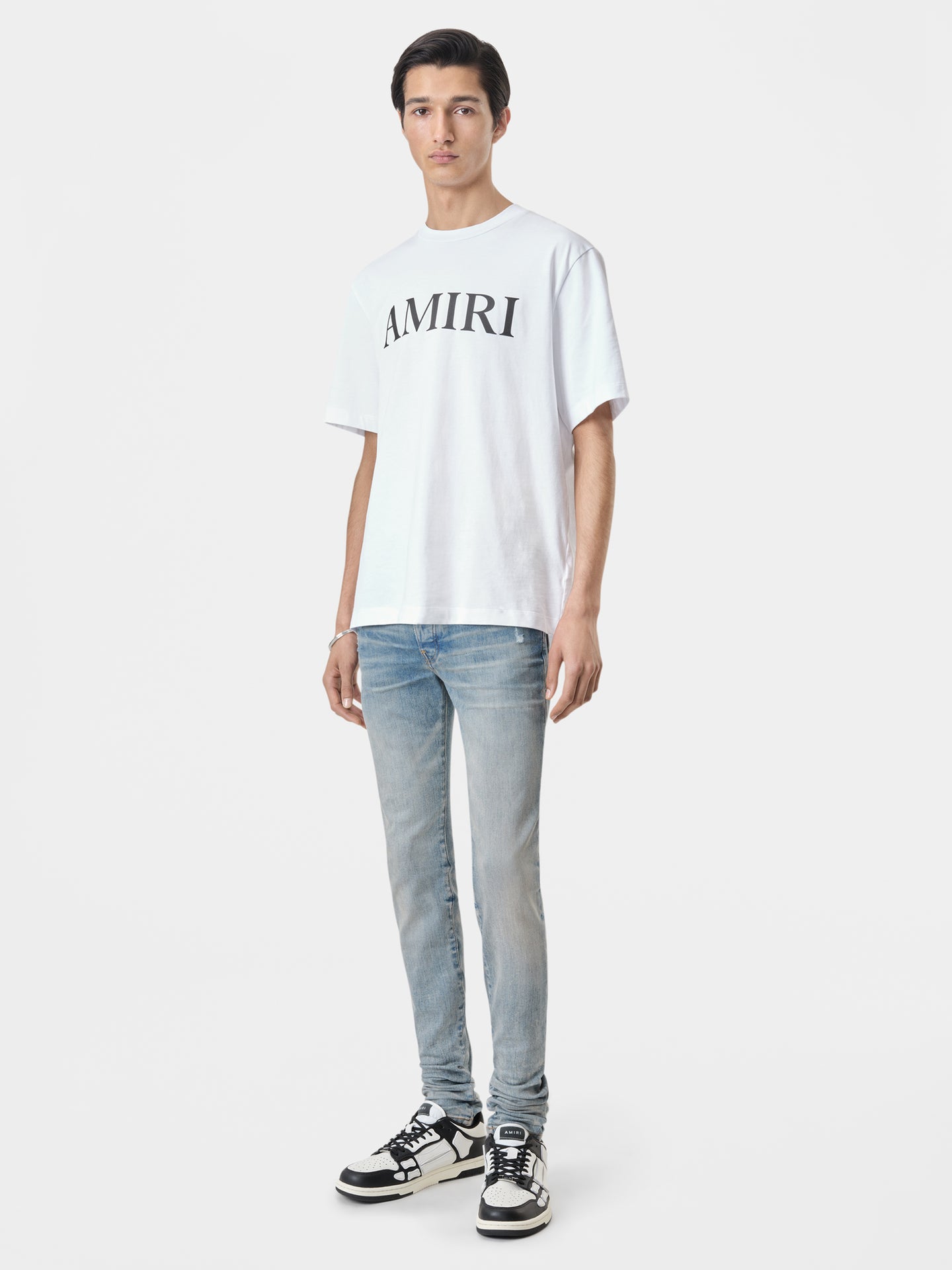 AMIRI Stack Jean in Clay Indigo with Amiri Logo Tee in White and Black White Classic Low Sneakers