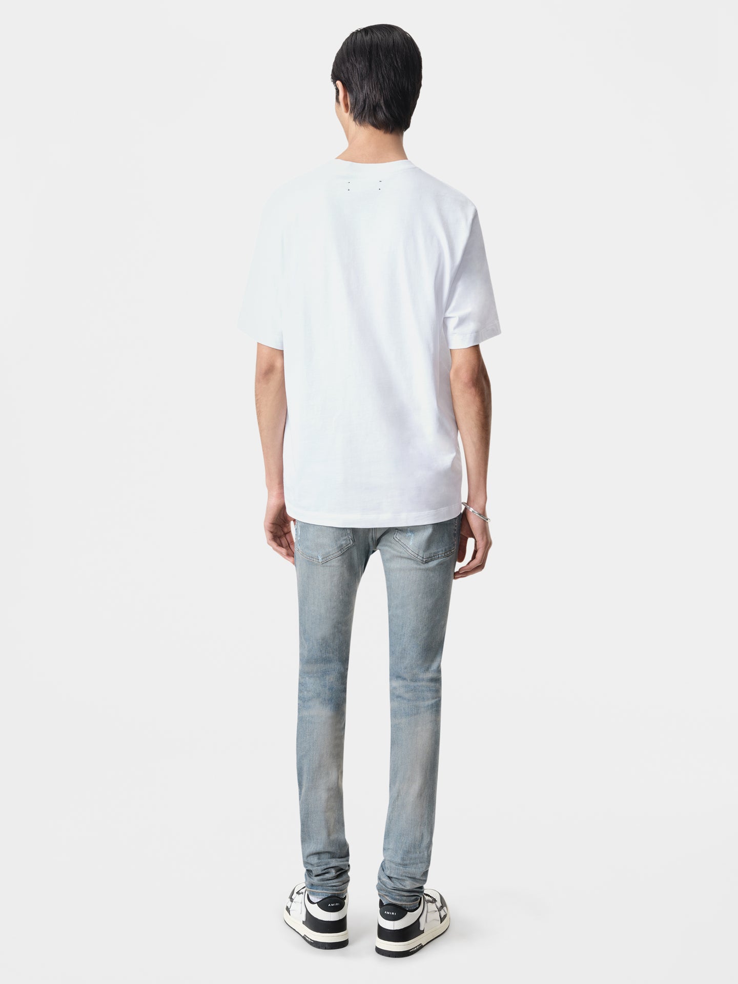 AMIRI Stack Jean in Clay Indigo with Amiri Logo Tee in White and Black White Classic Low Sneakers