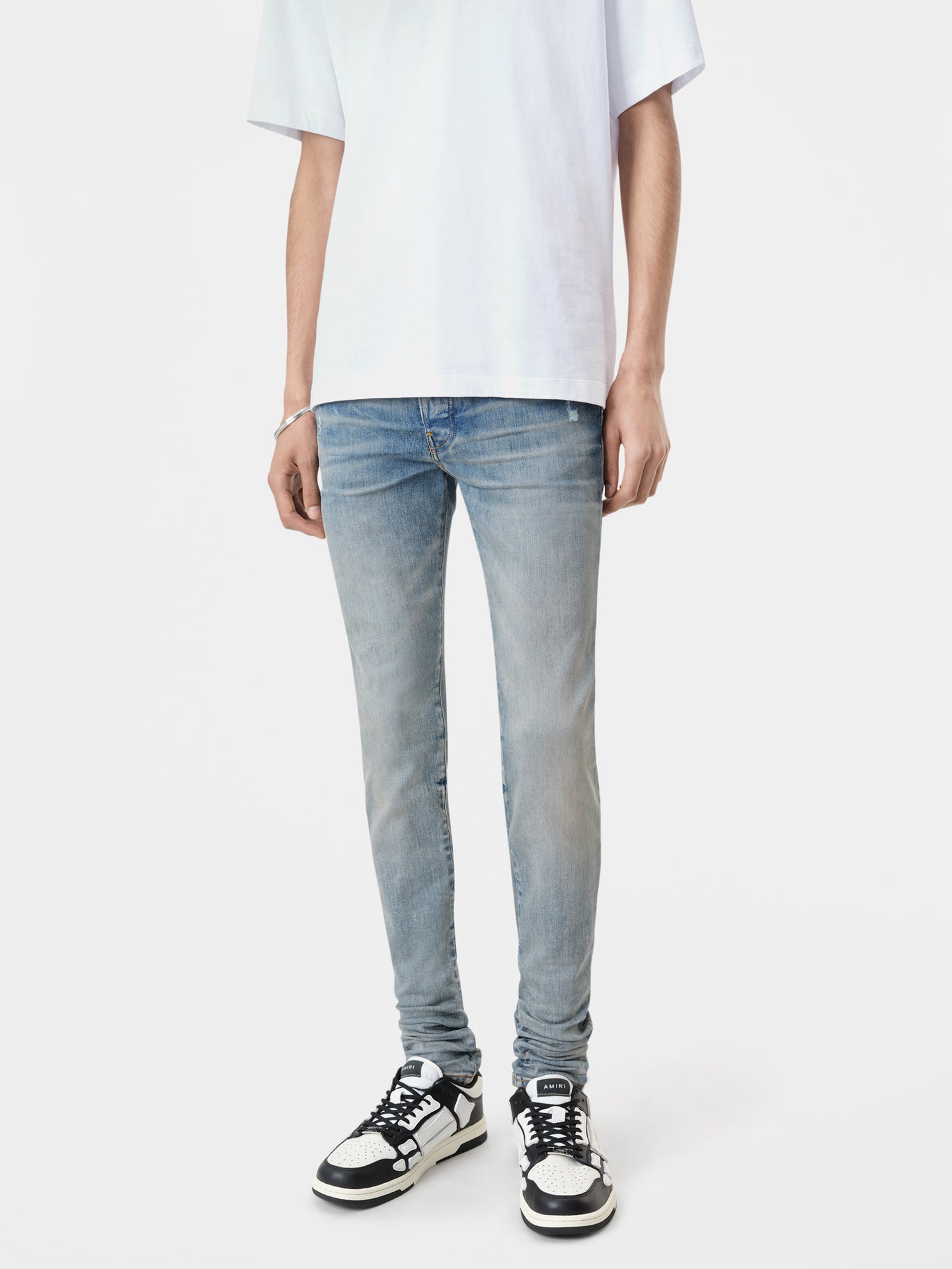 AMIRI Stack Jean in Clay Indigo with Amiri Logo Tee in White and Black White Classic Low Sneakers